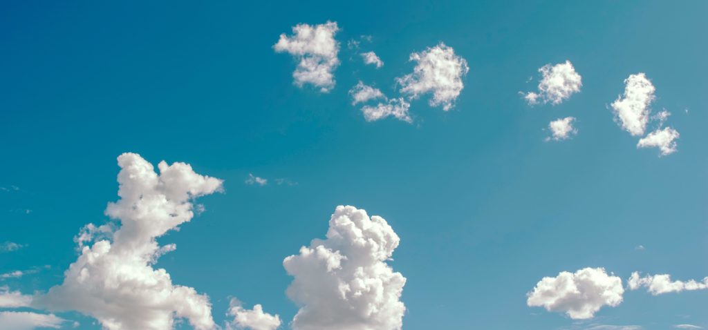 Białe, kłębiaste chmury na błękitnym niebie